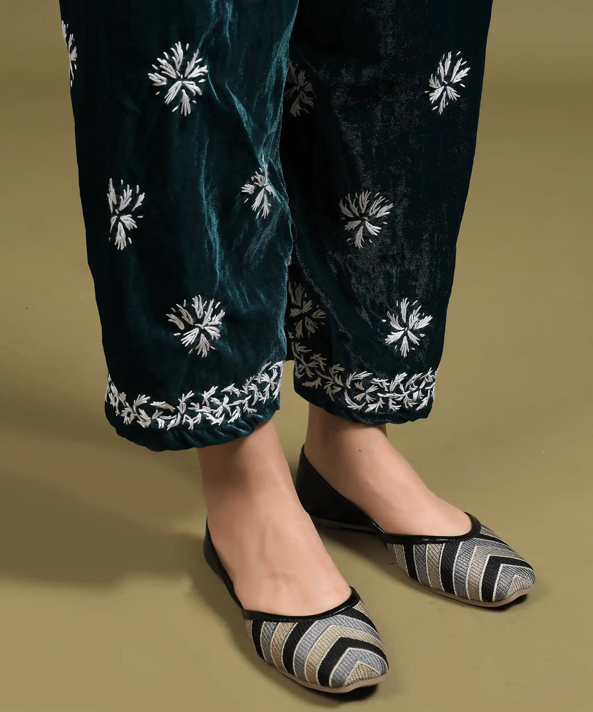 Close-up of white hand Chikankari embroidery on hem of bottle green velvet pant from Ruh kurta set — Noor-e-Awadh